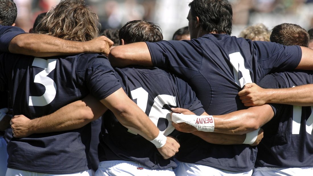 Équipe de rugby soudée, bras sur les épaules